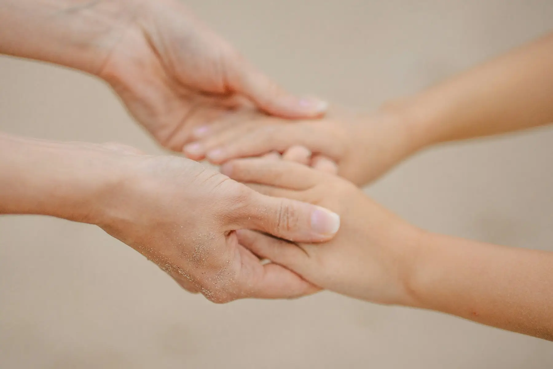 Duas pessoas de mãos dadas, num gesto de acolhimento