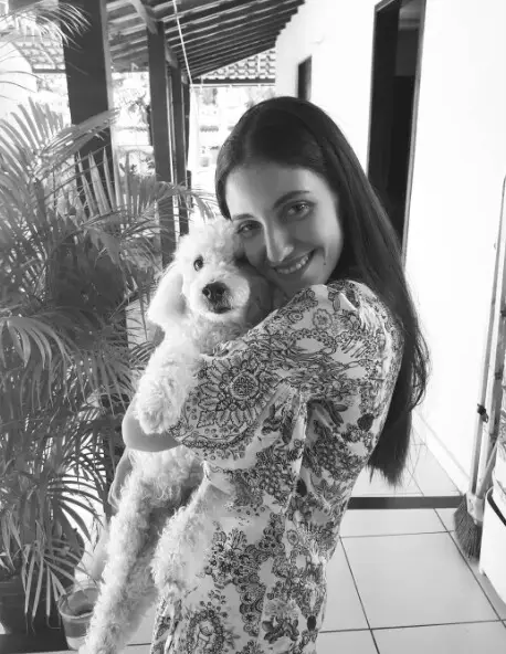Mayara Kersbaumer abraçando o seu cachorro, em foto preto e branco